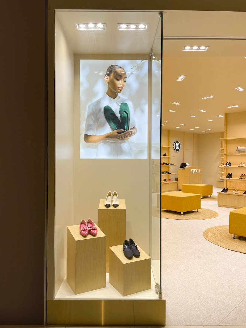 Shop entrance with a display window featuring shoes and a model.