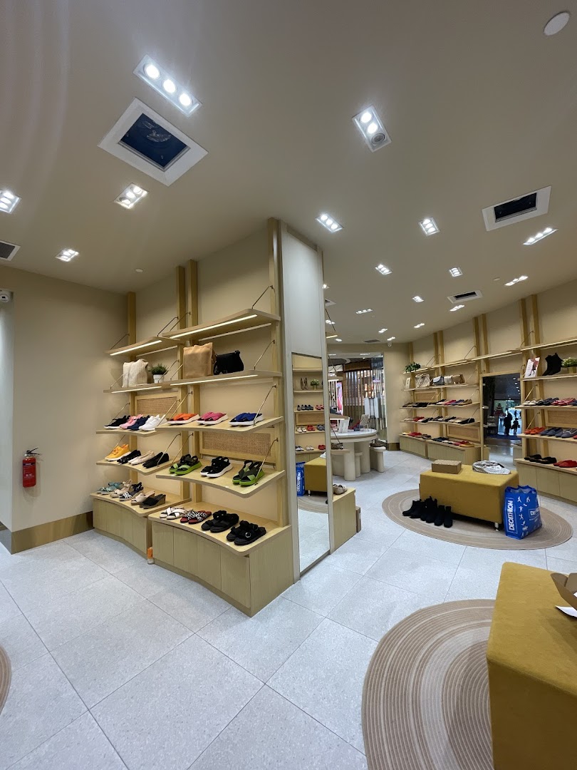 Interior view of a shoe store with shoes and bags displayed on shelves.