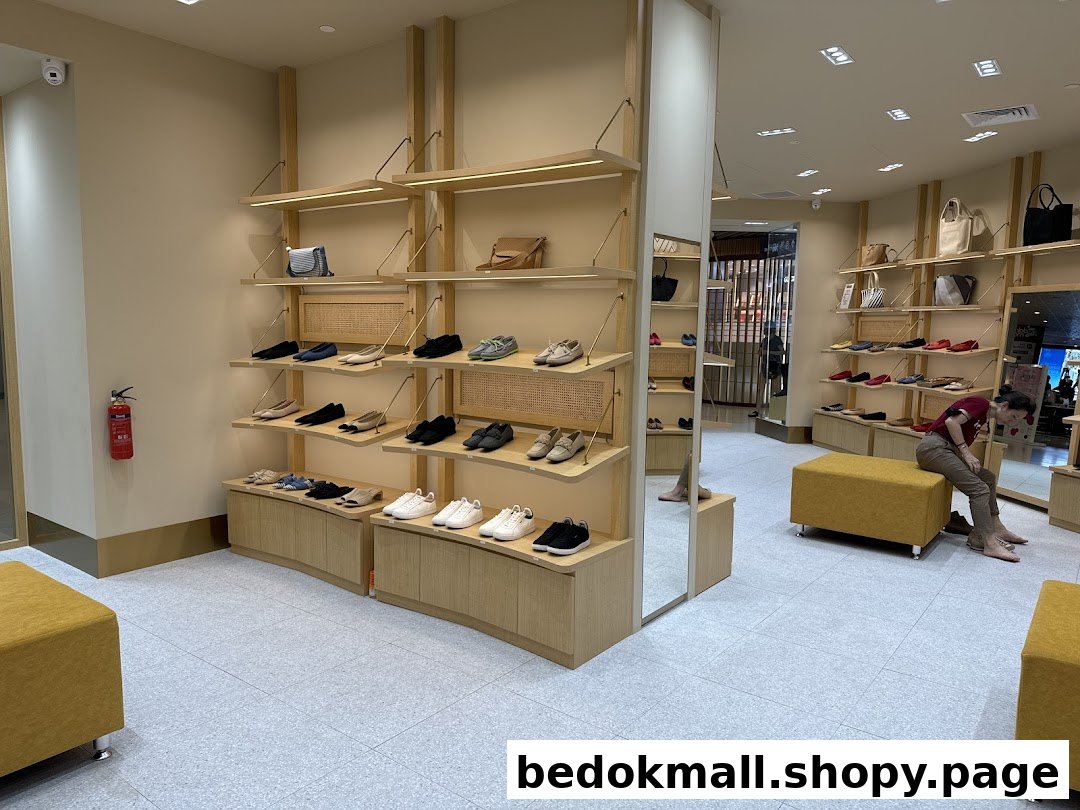 Interior of a shoe store with shoes on display and a customer trying them on.
