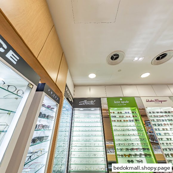 Interior view of an optical shop with multiple display cases of eyeglasses.