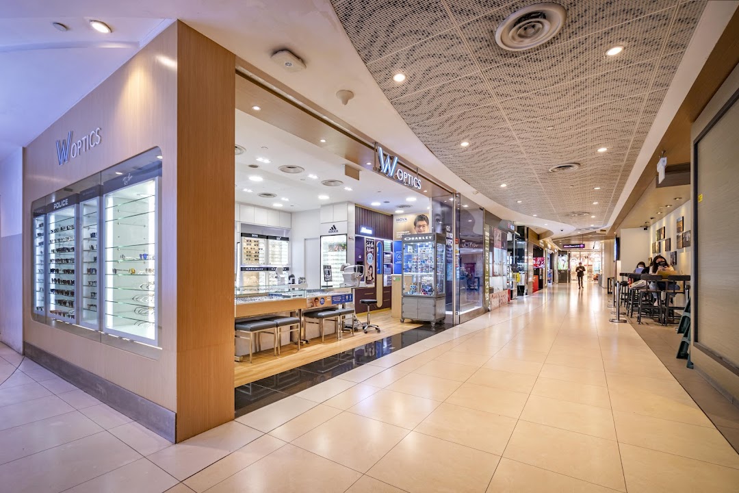 Exterior view of W Optics shop in a mall corridor with display windows.