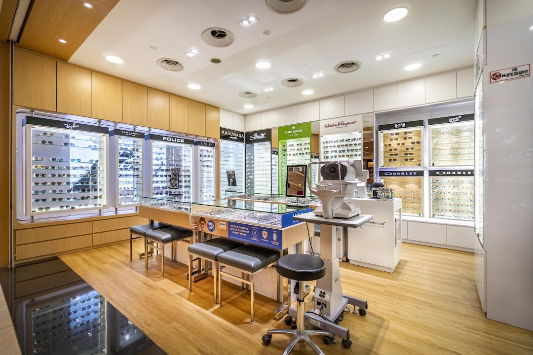 Interior of an optical shop with eyeglasses displays and an eye examination machine.