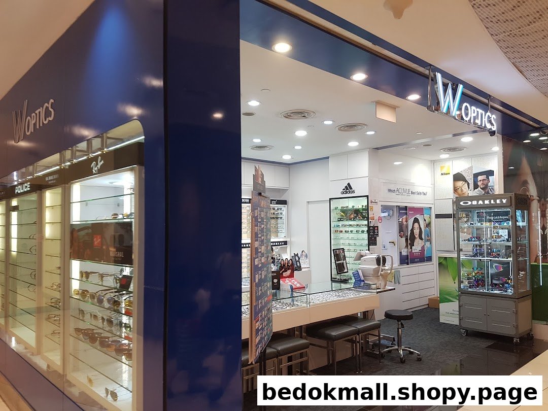 Interior view of an optical shop with display cases and an eye examination area.