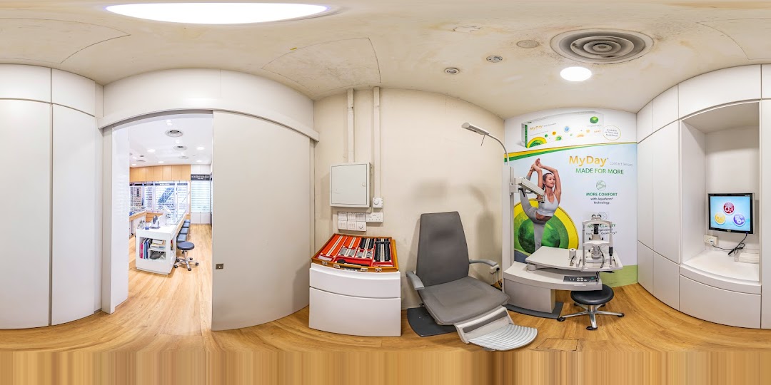 Interior view of an optical shop's examination room with equipment and retail area.