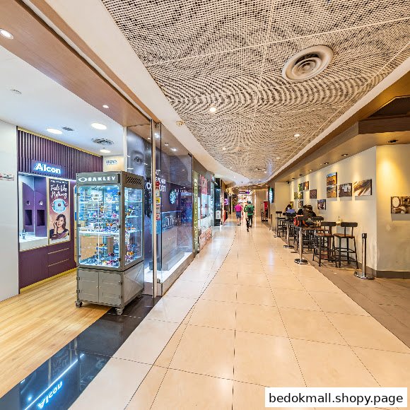 Interior view of a shop display and mall corridor with people.