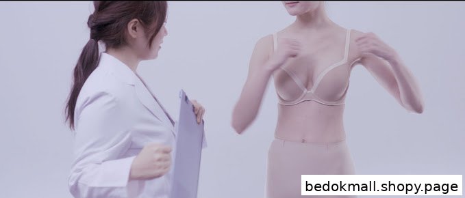 Woman in white coat assisting another wearing a bra and shapewear.