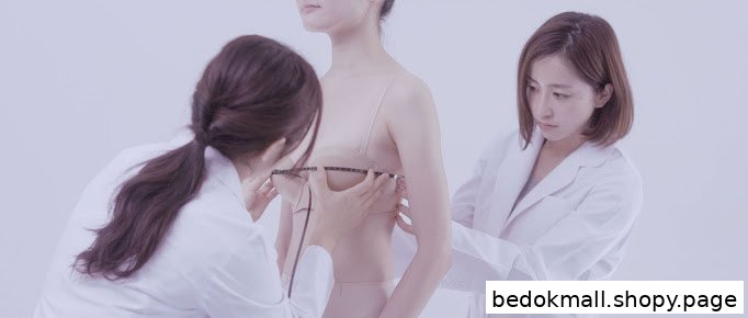 Two people in white coats measure a person's bust with a tape measure.