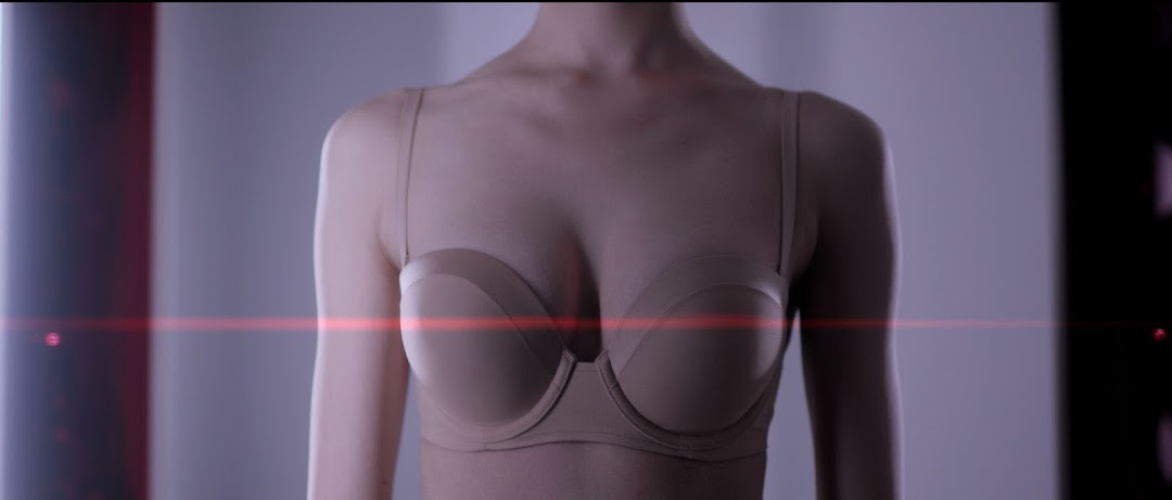 Mannequin or person wearing a beige bra with a red light streak.