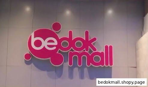 Pink and white 'bedok mall' sign on a light-colored wall.