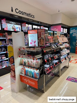 Interior view of a cosmetics section with various product displays in a retail store.