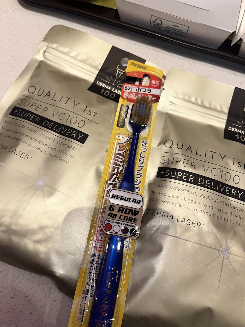 Close-up of a packaged toothbrush and two skincare pouches.