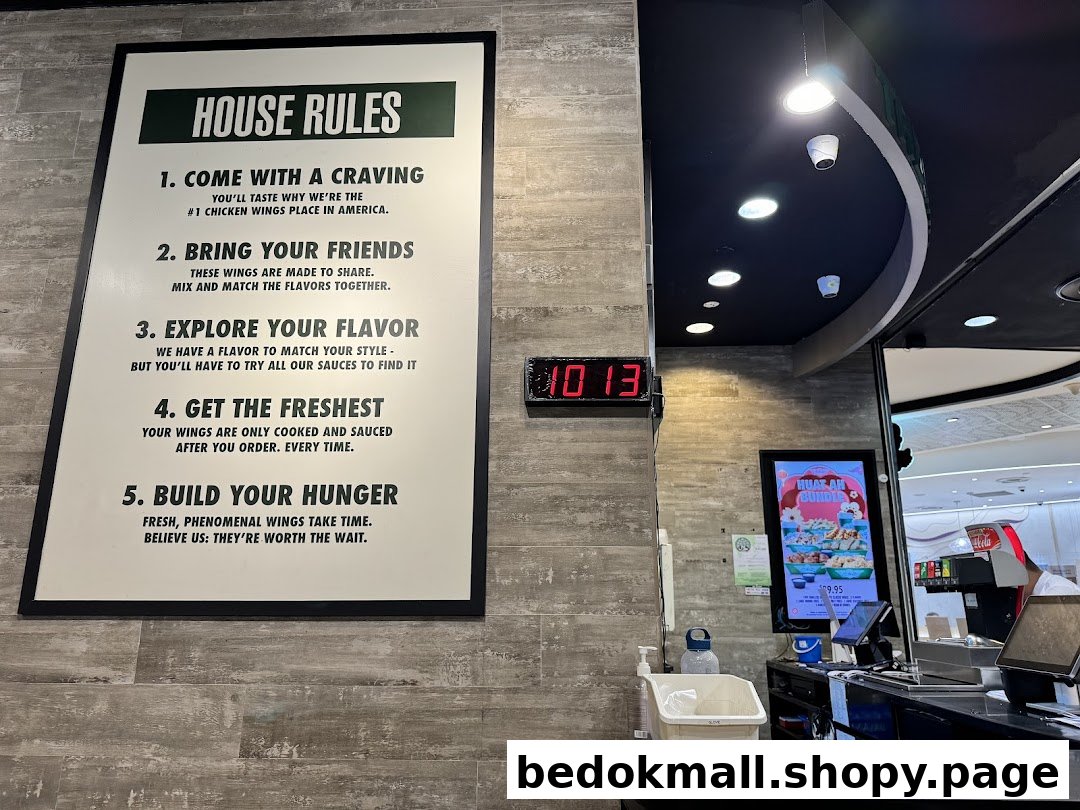 Interior shot of Wingstop with a 'House Rules' sign and order counter.