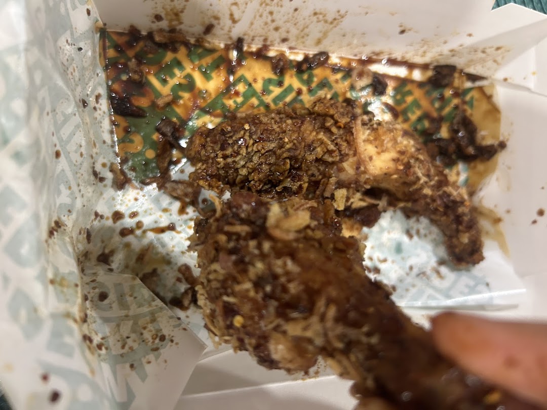 Sauced chicken wings in a Wingstop takeout box.