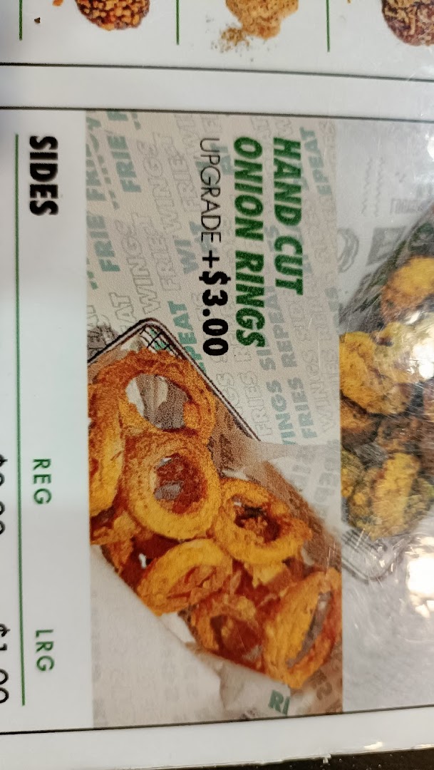 Close-up of a menu showing hand-cut onion rings with an upgrade price.