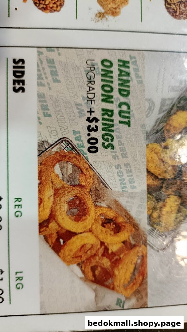 Close-up of a menu showing hand-cut onion rings with an upgrade price.