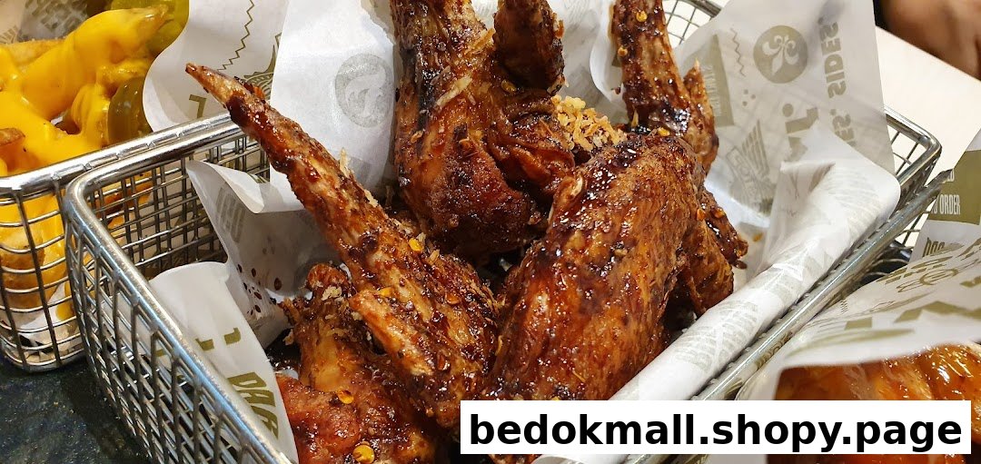 Close-up of chicken wings and fries in metal baskets.