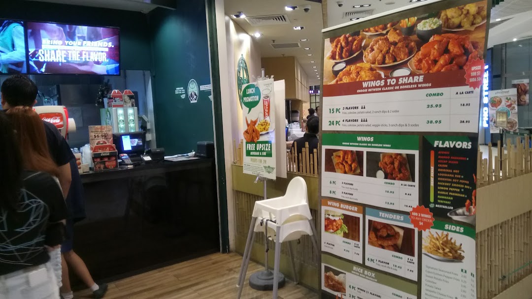 Interior view of Wingstop showing ordering counter and large menu board.