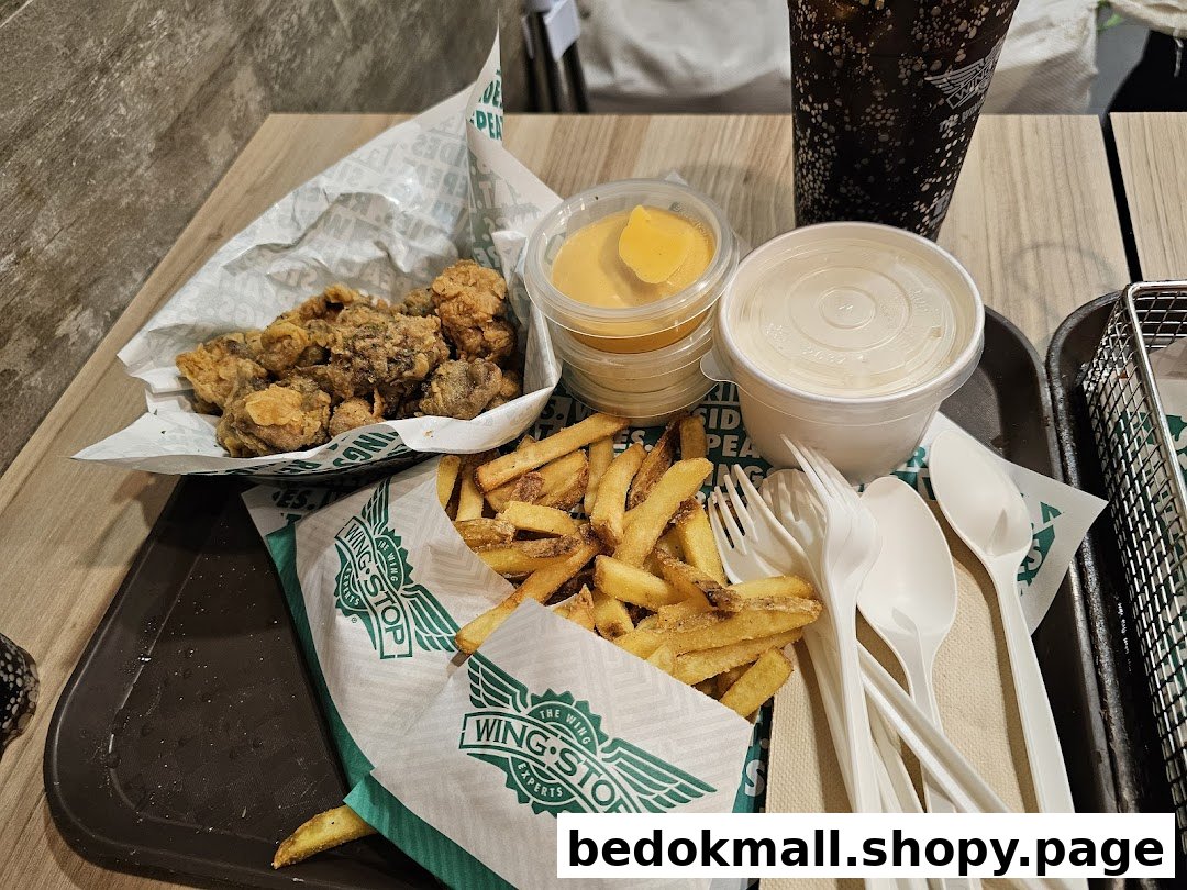 A tray with fried chicken, fries, sauces, a drink, and utensils.