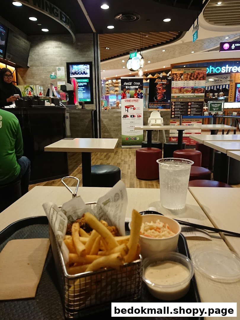 Interior view of a restaurant with food on a table and staff at the counter.
