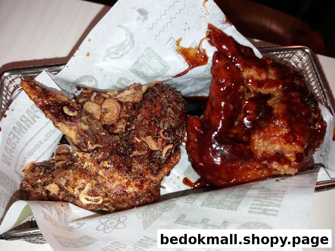 Two chicken wings, one dark and one red, served in a basket.