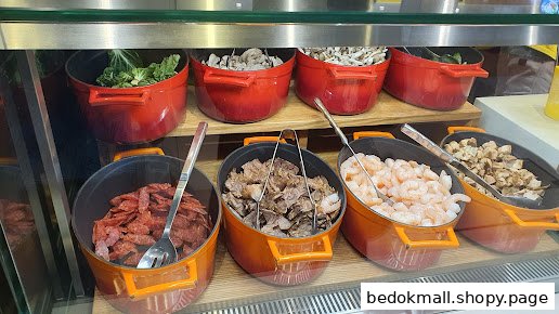 Pots of fresh ingredients like vegetables, meats, and seafood displayed behind a counter.