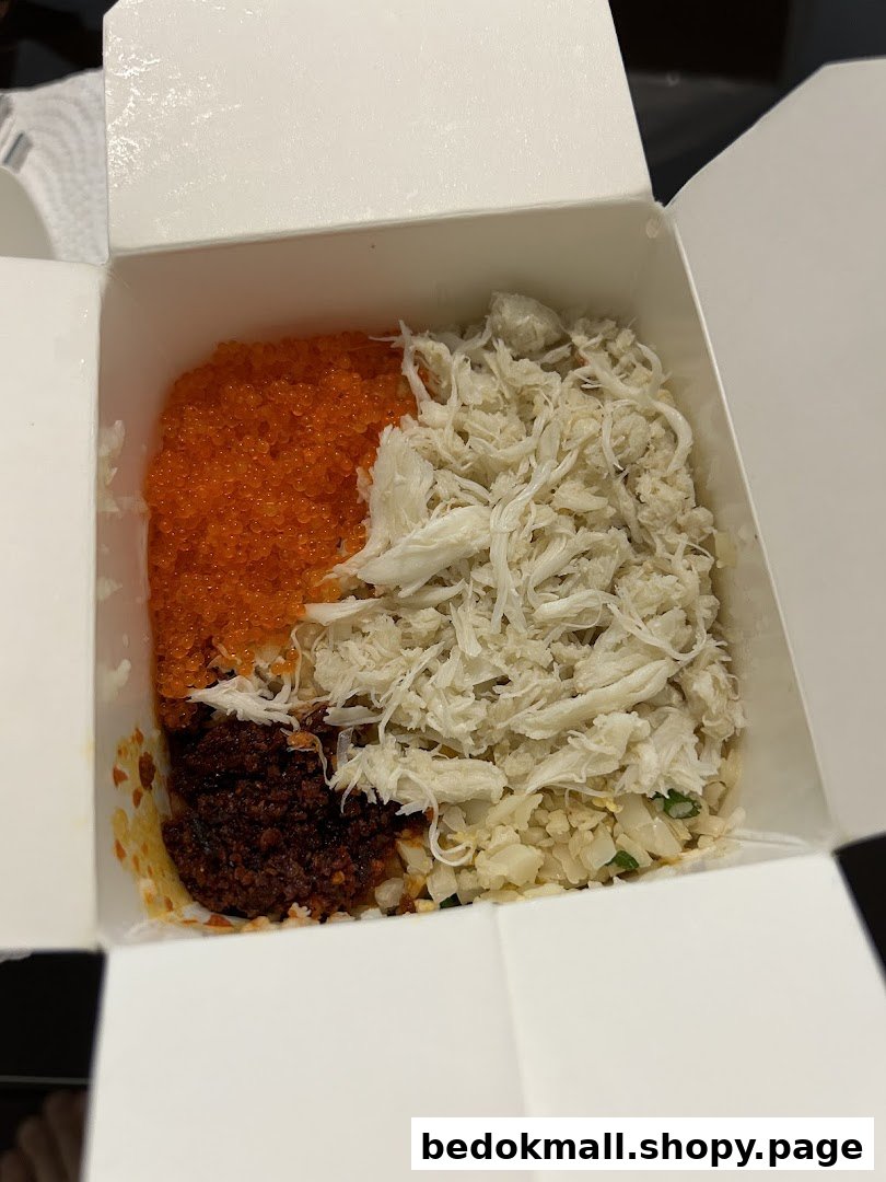Takeaway box with rice, crab meat, roe, and chili paste.