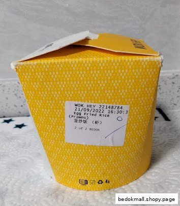 A yellow takeaway box with an Egg Fried Rice (Prawns) label from WOK HEY.