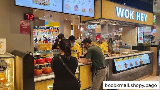 Customers and staff at a WOK HEY food stall in a mall.