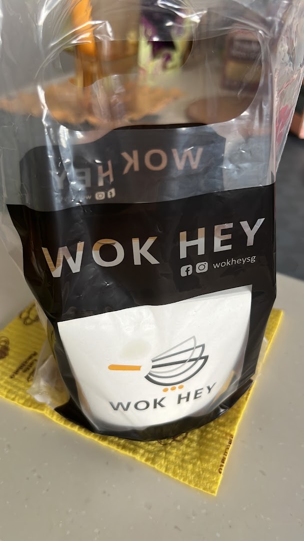 WOK HEY branded food container in a clear plastic bag on a counter.