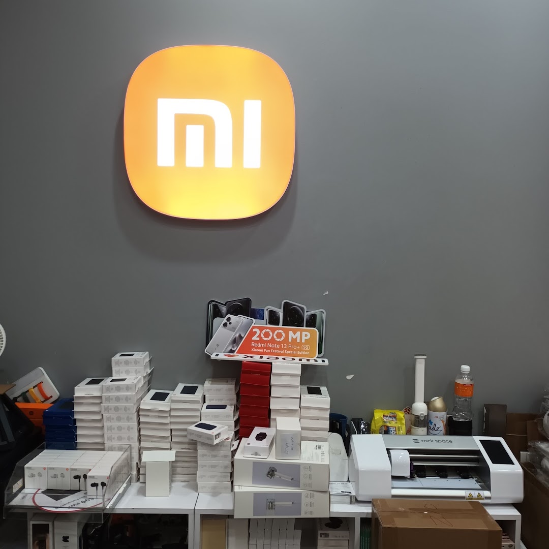 Interior shot of a Xiaomi shop with product boxes and equipment on a counter.