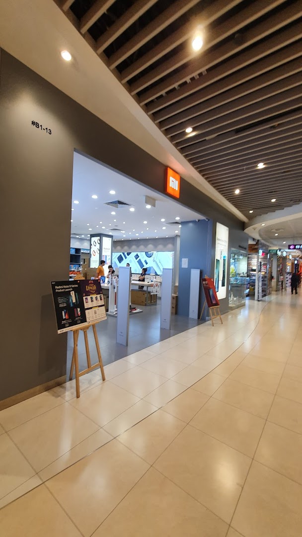 Entrance of a Xiaomi store in a mall with a promotional stand.