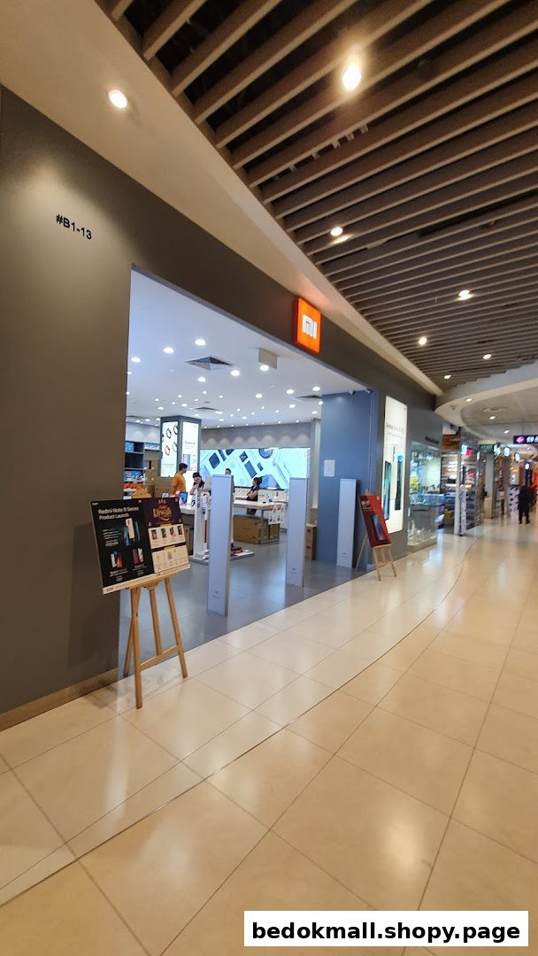 Entrance of a Xiaomi store in a mall with a promotional stand.