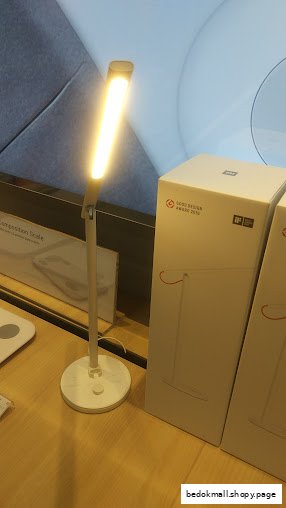 An illuminated desk lamp and product boxes on a display table.