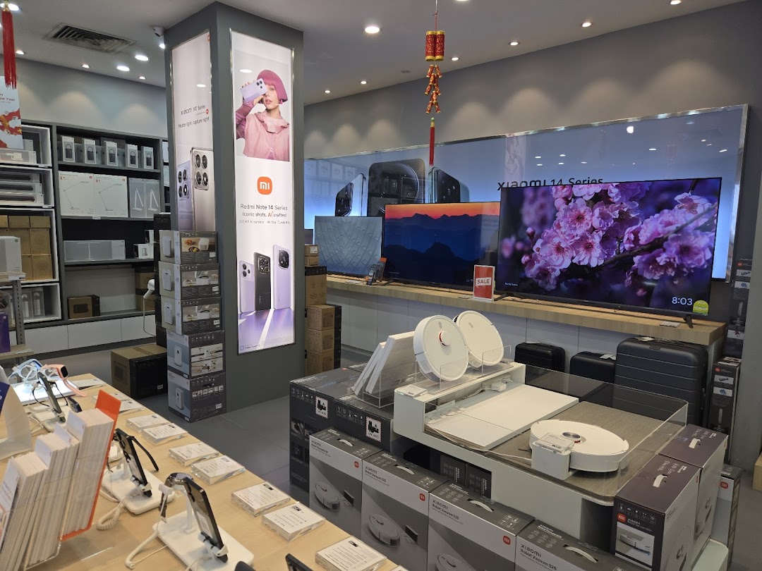 Interior of a Xiaomi store displaying electronics like phones, TVs, and robot vacuums.