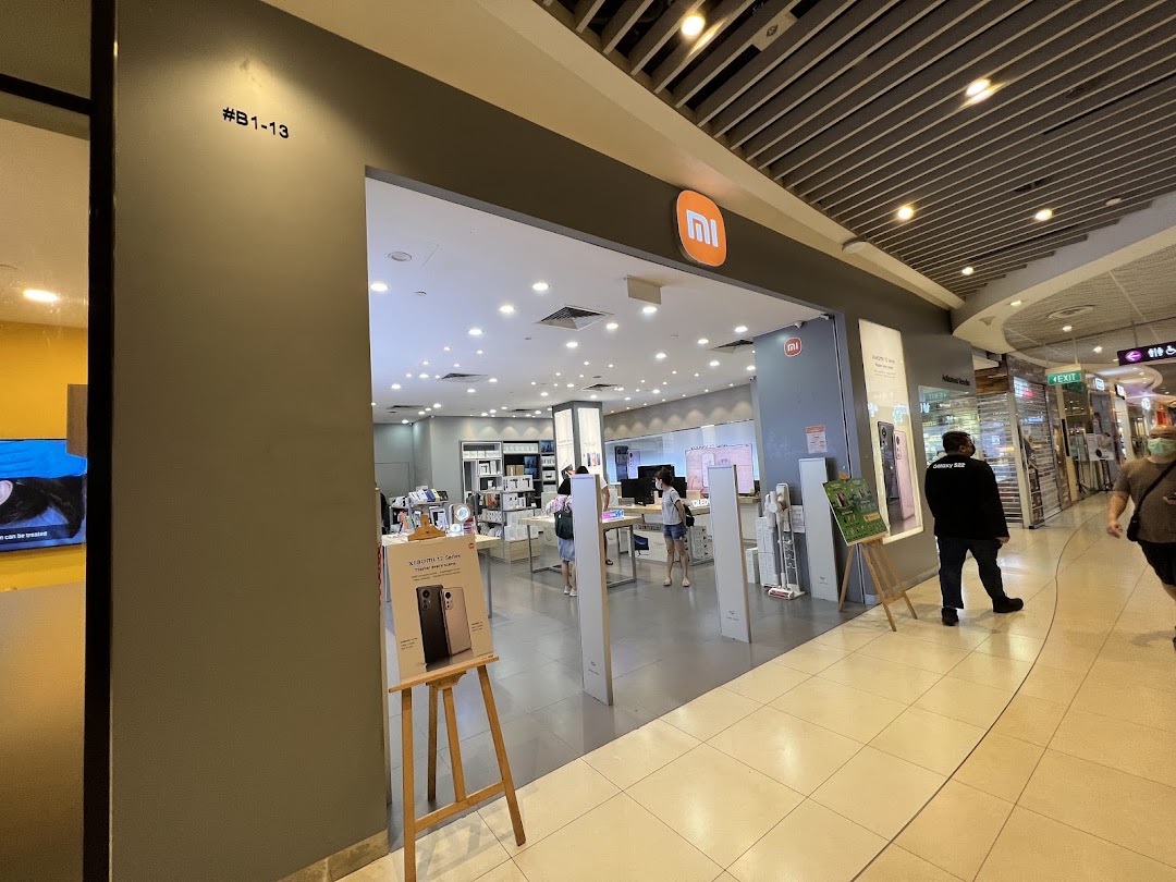 Entrance of a Xiaomi store in a mall with people walking by.
