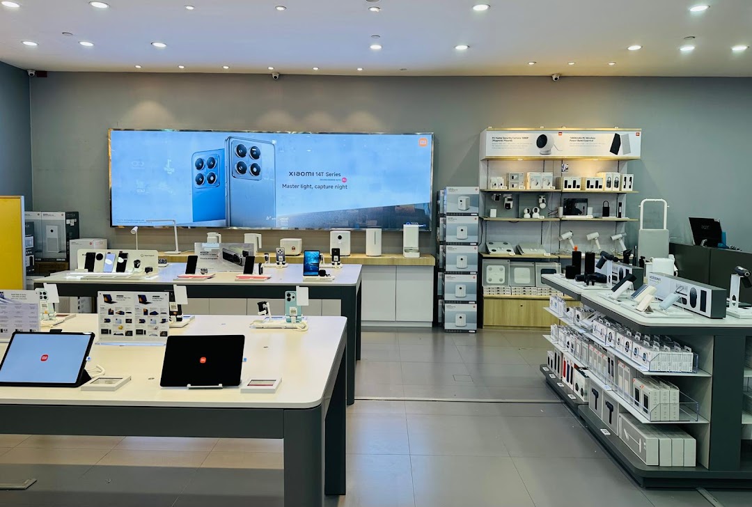 Interior view of a modern electronics store with display tables and product shelves.