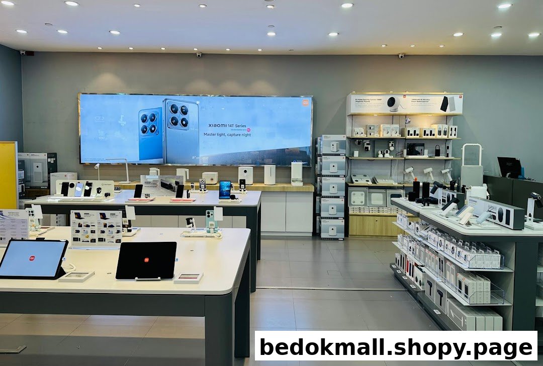 Interior view of a modern electronics store with display tables and product shelves.