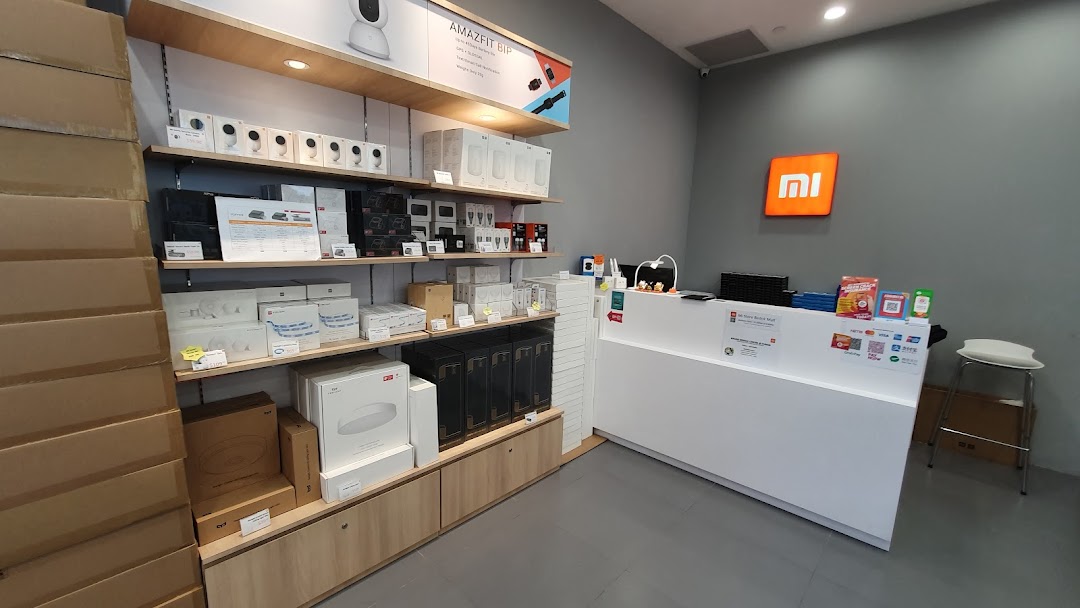 Inside a Xiaomi store showing product displays, boxes, and a service counter.