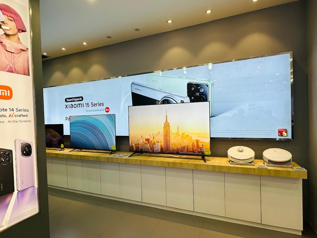 Interior view of a Xiaomi store displaying TVs, phones, and robot vacuums.