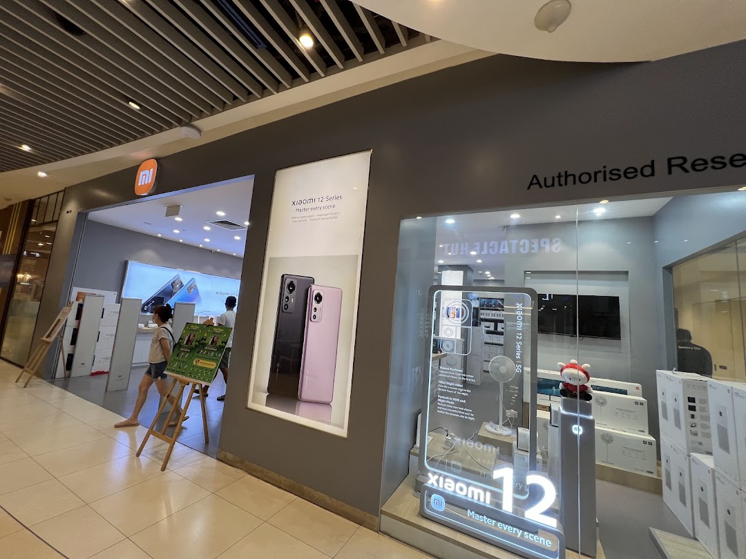 Front of a Xiaomi store with product displays and customers.