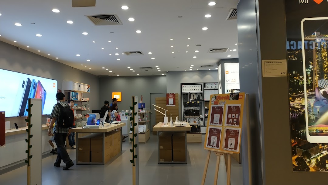 Interior view of a Xiaomi store with products on display and customers.