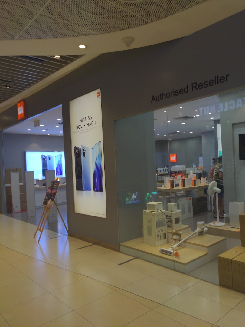 Xiaomi store front with large display and products visible through glass.