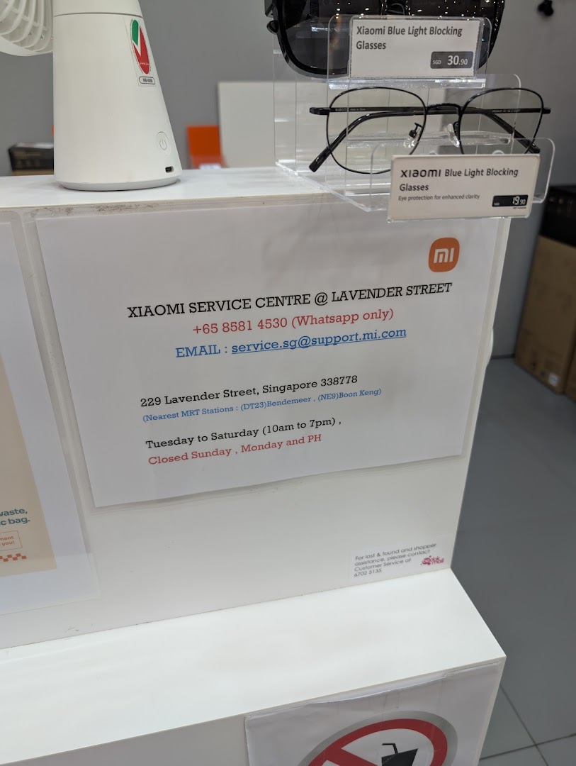 Counter with Xiaomi service center information and blue light blocking glasses.