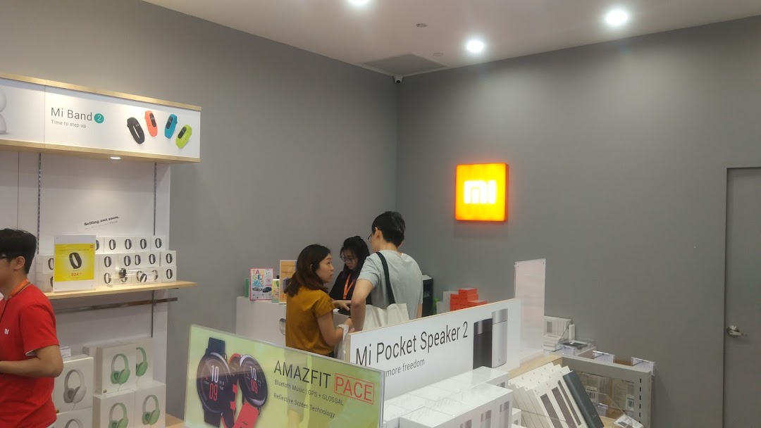 Interior view of a Xiaomi store with product displays and customers.