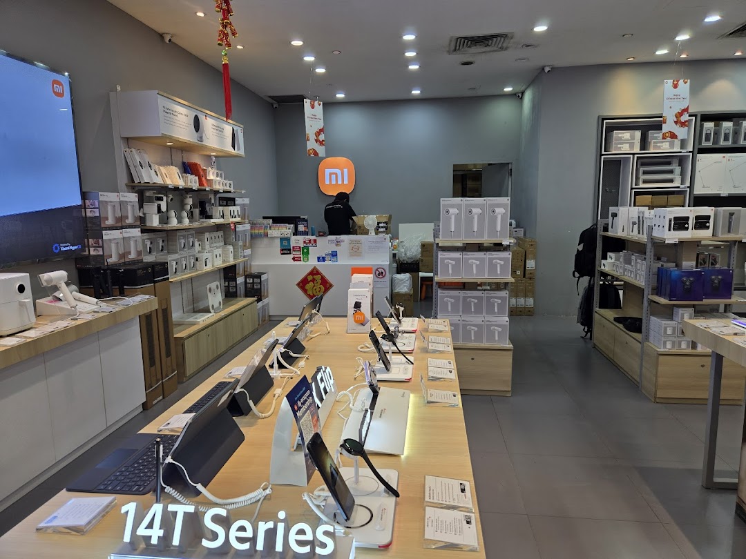 Interior of a Xiaomi store displaying various electronics, with a counter and staff.