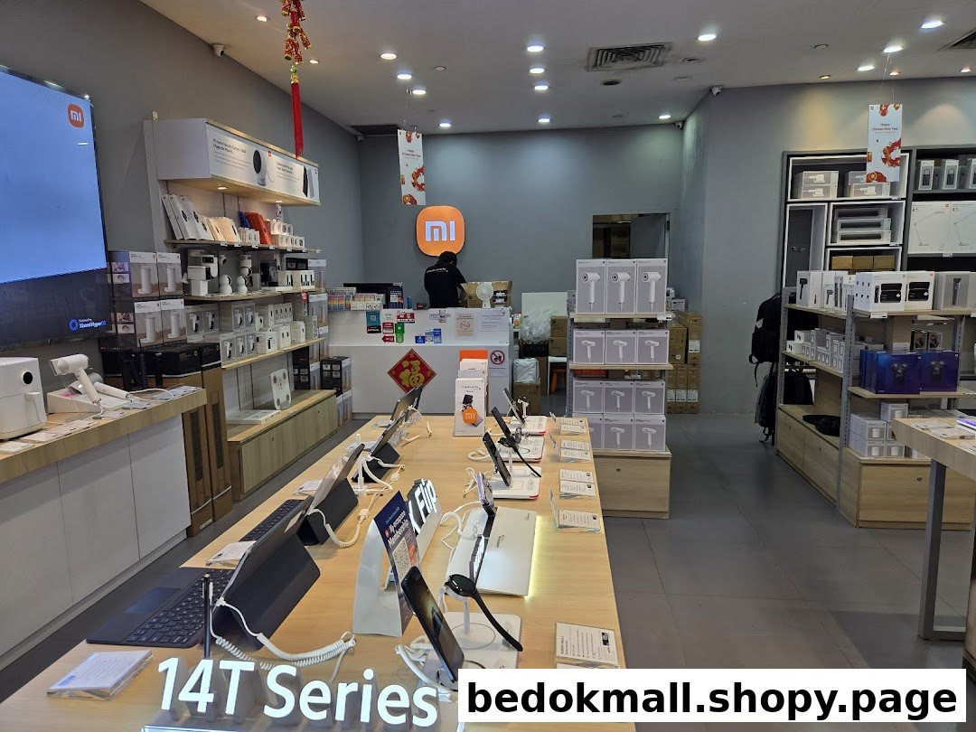 Interior of a Xiaomi store displaying various electronics, with a counter and staff.