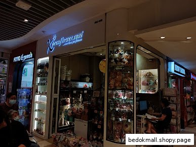 The storefront of Xpressflower.com in a mall, displaying various products.