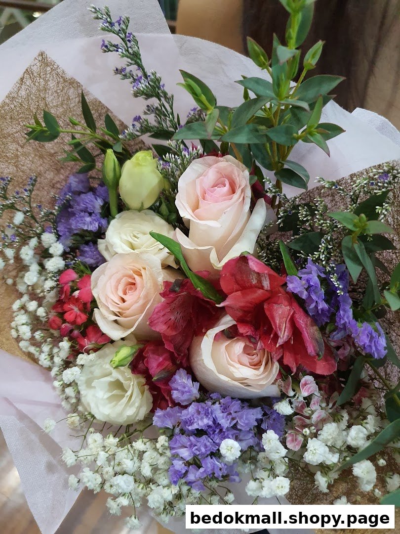 A vibrant bouquet featuring pink and white roses, baby's breath, and purple flowers.