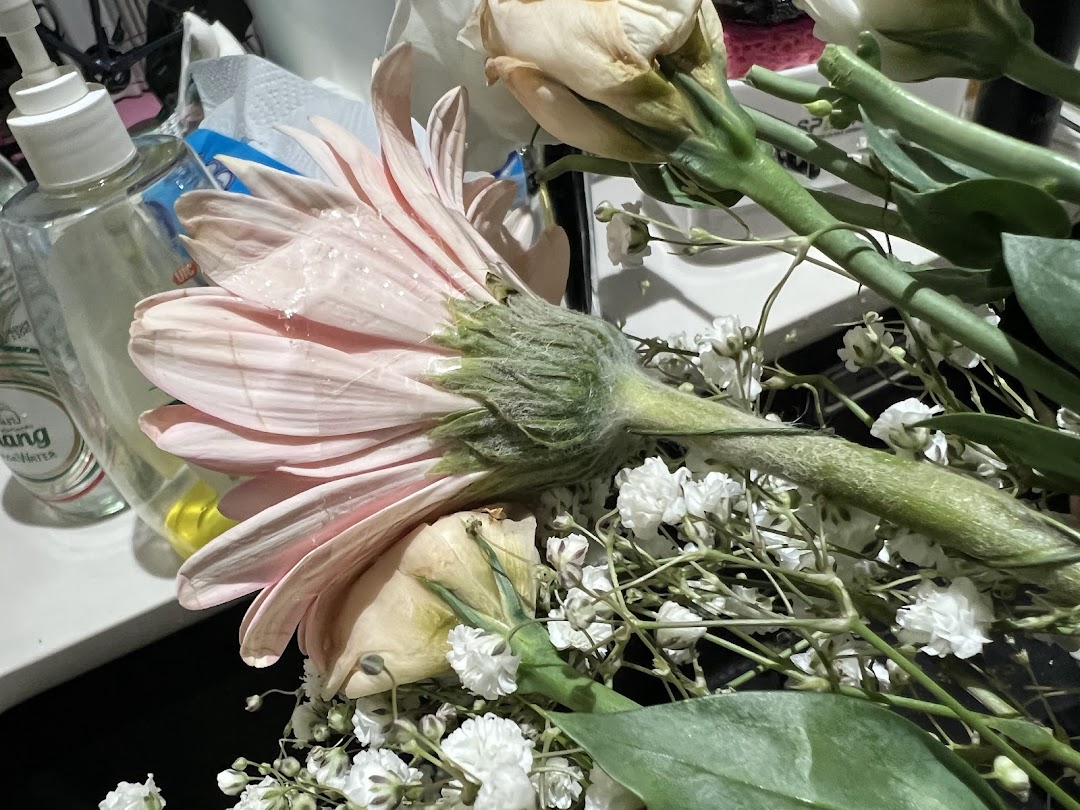 Close-up of a bouquet of flowers next to a hand sanitizer bottle.