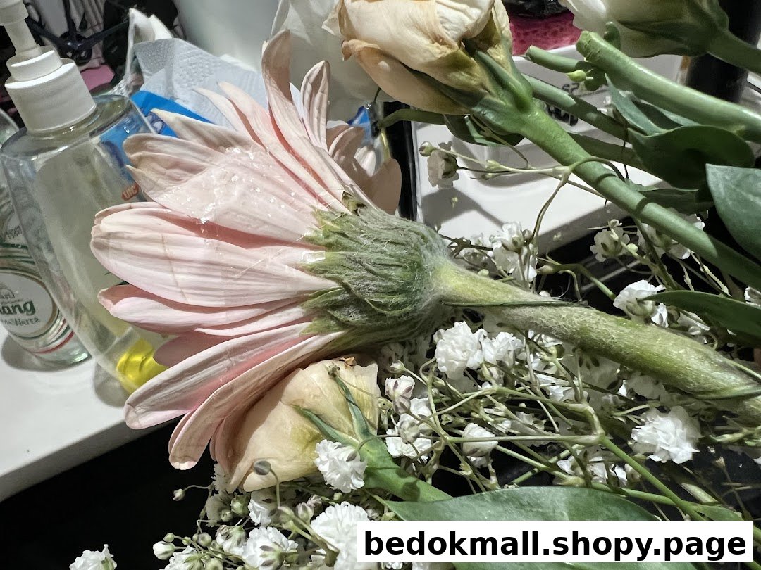 Close-up of a bouquet of flowers next to a hand sanitizer bottle.
